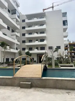 a large building with a wooden boardwalk in front of a pool at Trendy Condo - Stunning Views in Aïn Harrouda