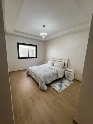 a white bedroom with a bed and a window at Trendy Condo - Stunning Views in Aïn Harrouda