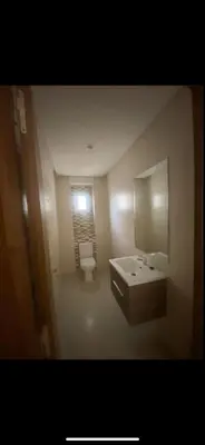a bathroom with a sink and a toilet and a mirror at La résidence de Palais in Bouskoura