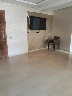a room with a flat screen tv on a wall at La résidence de Palais in Bouskoura