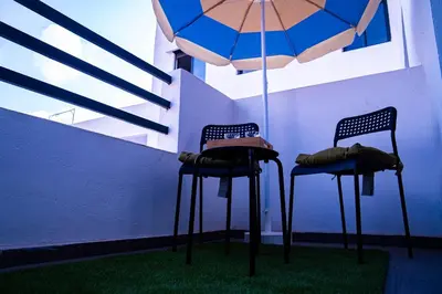 two chairs and a table with an umbrella at R102- Stylish and Functional 1 BR Apartment at the center of Belvedere in Casablanca
