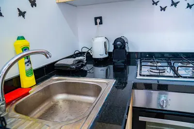 a kitchen counter with a sink and a stove at R102- Stylish and Functional 1 BR Apartment at the center of Belvedere in Casablanca