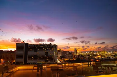 a view of a city at sunset from a balcony at R102- Stylish and Functional 1 BR Apartment at the center of Belvedere in Casablanca