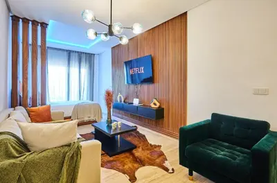 a living room with a green couch and a bed at Casablanca Maarif in Maarif