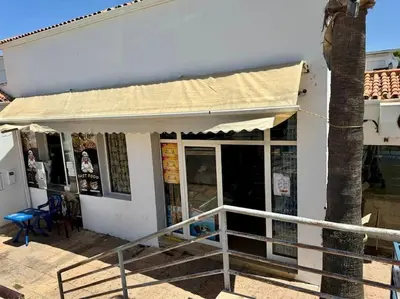 a white building with awning next to a palm tree at La perle de Tamaris in Casablanca