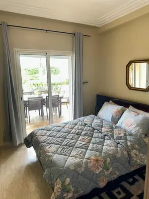 a bedroom with a bed and a view of a table at La perle de Tamaris in Casablanca
