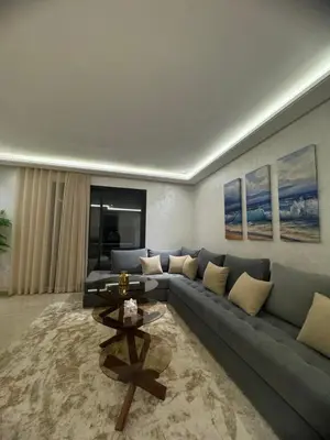a living room with a blue couch and a table at Appartement de prestige à Casablanca in Casablanca