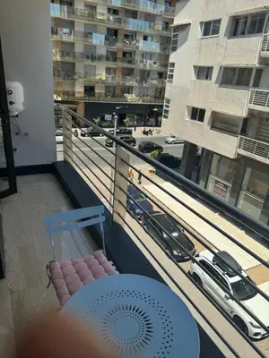 a balcony with a chair and a view of a city at Appartement de prestige à Casablanca in Casablanca