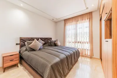 a bedroom with a large bed and a window at Casablanca Centre Confort Luxe Emplacement idéal in Maarif