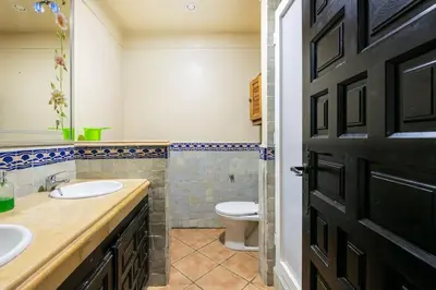 a bathroom with a toilet and a sink and a door at Résidence beach house in Dar Bouazza
