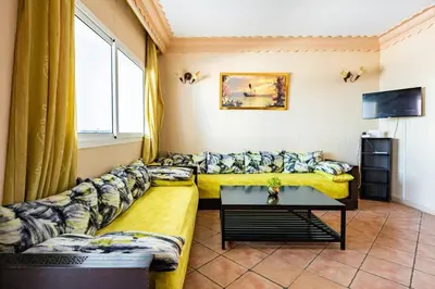 a living room with a couch and a tv at Résidence beach house in Dar Bouazza