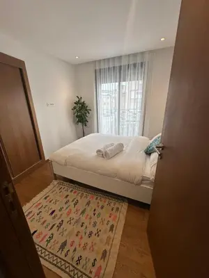 a bedroom with a bed with a rug and a window at Haut Standing 2-Bedroom Apartment in Gauthier in Casablanca