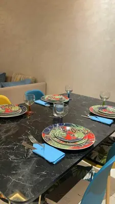 a table with plates and wine glasses on it at Studio Charmant & Cosy à Agdal in Gare de Rabat-Aguedal