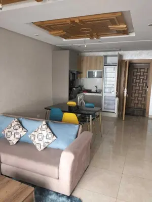 a living room with a couch and a kitchen at Studio Charmant & Cosy à Agdal in Gare de Rabat-Aguedal