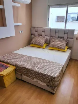 a bedroom with a large bed with pillows on it at Studio Charmant & Cosy à Agdal in Gare de Rabat-Aguedal