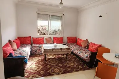 a living room with a couch with red pillows at Appartement à Louer à Casablanca in Casablanca