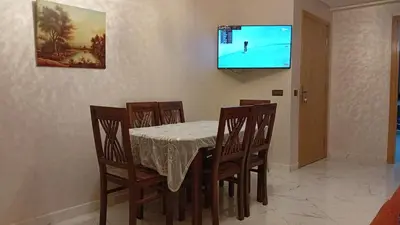 a dining room with a table and chairs and a television at Welcomeمرحبا in Casablanca