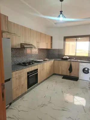 a kitchen with wooden cabinets and a white appliance at Welcomeمرحبا in Casablanca
