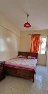 a bedroom with a bed with pink sheets and a window at Residence Louma in Mohammedia