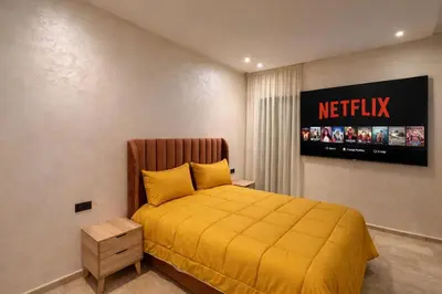a bedroom with a yellow bed with a sign on the wall at Luxury 2Ch Face Plage 3 Piscines Jardin in Tamaris