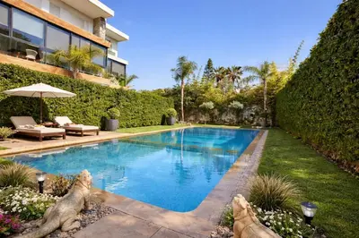a swimming pool in the backyard of a house at Luxury 2Ch Face Plage 3 Piscines Jardin in Tamaris
