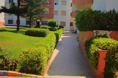 a sidewalk in front of a building with bushes at Mohammedia Appartement in Mohammedia