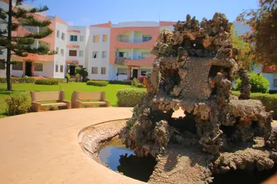 a fountain in a yard with a building in the background at Mohammedia Appartement in Mohammedia