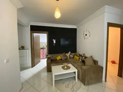 a living room with a couch and a table at Résidence MaRwa in Oulad Kerroum