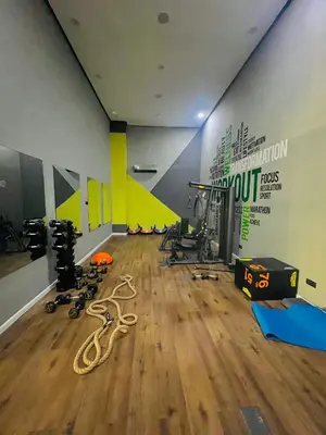 a gym with a bunch of equipment on a wooden floor at Appartement Dahlia - Haut Standing - Mohammedia Natura Living in Mohammedia