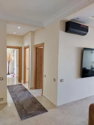 a living room with a tv on a wall at Cosy Apartment with sea view in Sidi Rahal