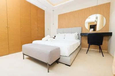 a bedroom with a bed and a chair and a mirror at Luxury 2BR Apartment in Agdal for a Relaxing Stay in Es Souissi