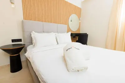 a bedroom with a bed with white sheets and a table at Luxury 2BR Apartment in Agdal for a Relaxing Stay in Es Souissi