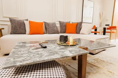 a living room with a couch and a table at Luxury 2BR Apartment in Agdal for a Relaxing Stay in Es Souissi