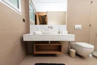 a bathroom with a sink and a toilet and a mirror at Luxury 2BR Apartment in Agdal for a Relaxing Stay in Es Souissi