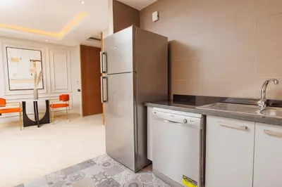 a kitchen with a stainless steel refrigerator in a room at Luxury 2BR Apartment in Agdal for a Relaxing Stay in Es Souissi