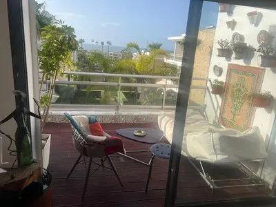 a balcony with a table and chairs on a balcony at Eden in Dar Bouazza