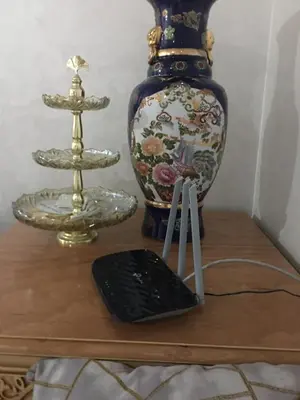 a table with a vase and a remote control on it at Résidence les deux palmiers Temara Rabat in Temara
