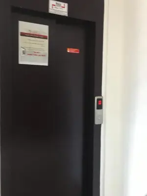 a black refrigerator with two signs on the side of it at Résidence les deux palmiers Temara Rabat in Temara