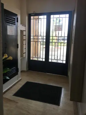 a door with a gate and a rug in a hallway at Résidence les deux palmiers Temara Rabat in Temara