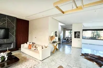 a living room with a white couch and a fireplace at Poolside Paradise Villa in Dar Ben Abdallah Ben Dehbi
