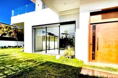 a white house with glass windows and a door at Poolside Paradise Villa in Dar Ben Abdallah Ben Dehbi