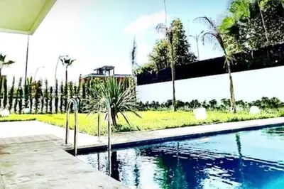 a swimming pool in a yard with palm trees at Poolside Paradise Villa in Dar Ben Abdallah Ben Dehbi