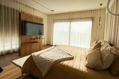 a bedroom with a large bed and a flat screen tv at Poolside Paradise Villa in Dar Ben Abdallah Ben Dehbi