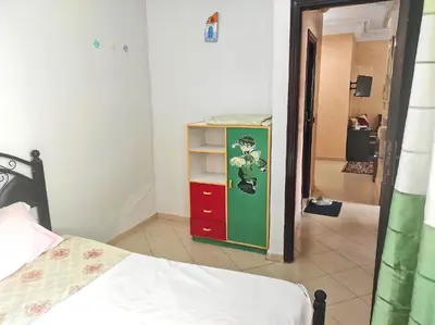 a bedroom with a bed and a cabinet with red draws at Appartement familial calme 3 min à Casanearshore in Casablanca