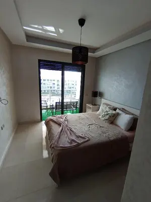 a bedroom with a large bed and a large window at Magnifique appart vue piscine 5min de la plage in Kasba Bou Hamira