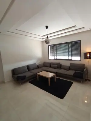 a living room with a couch and a table at Magnifique appart vue piscine 5min de la plage in Kasba Bou Hamira