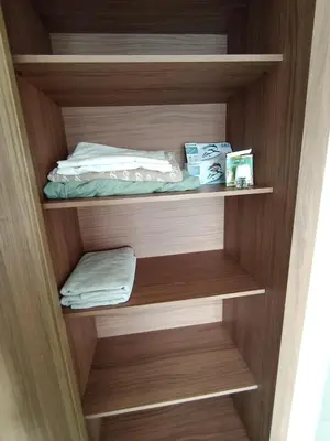 a cupboard with a bed and towels in it at Magnifique appart vue piscine 5min de la plage in Kasba Bou Hamira