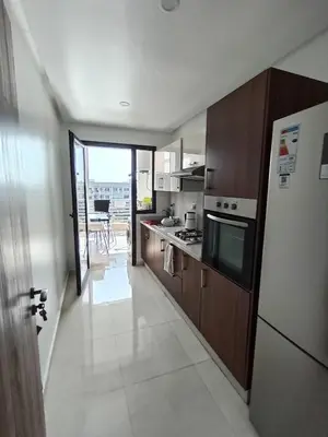 a kitchen with a refrigerator and a counter top at Magnifique appart vue piscine 5min de la plage in Kasba Bou Hamira