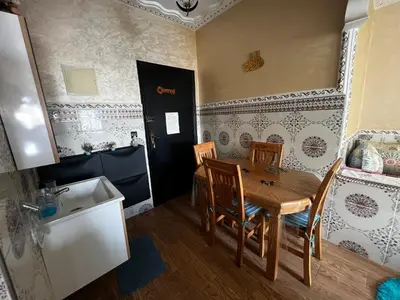 a kitchen with a table and chairs in a room at Apartment à 1 min de Casanearshore in Casablanca