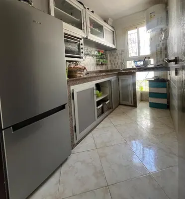 a kitchen with a refrigerator and a tile floor at Appart meublé 5min de la plage à Bouznika in Bouznika